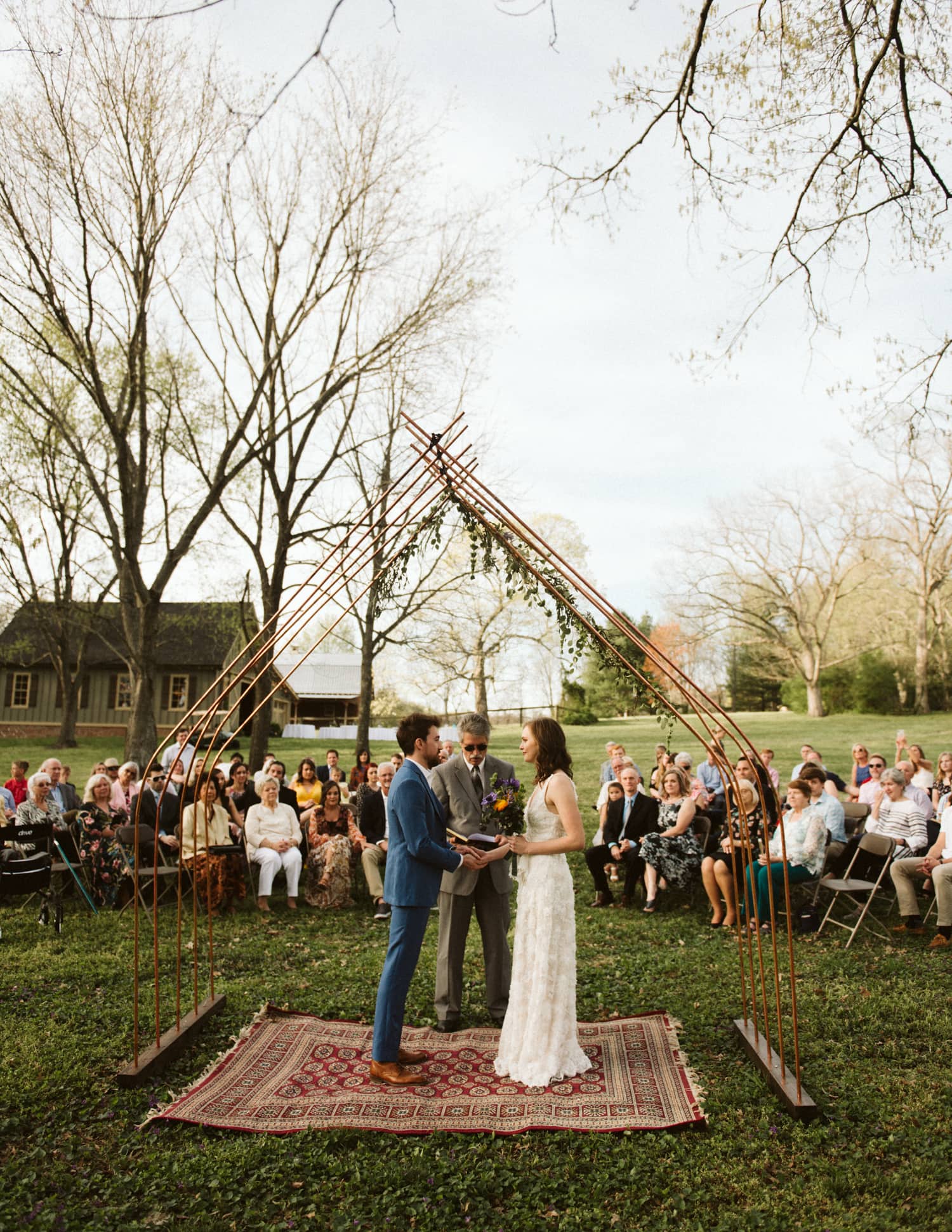 Bride and groom standing under their handmade arch during their cozy, intimate ceremony in Franklin, Tennessee