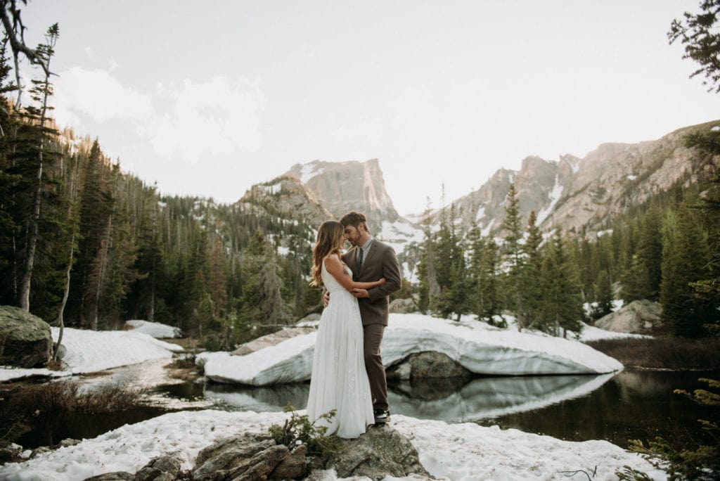 Bride and groom hugging in Rocky Mountain National Park, Colorado, the day after their wedding. Hiking elopement ideas to Dream Lake