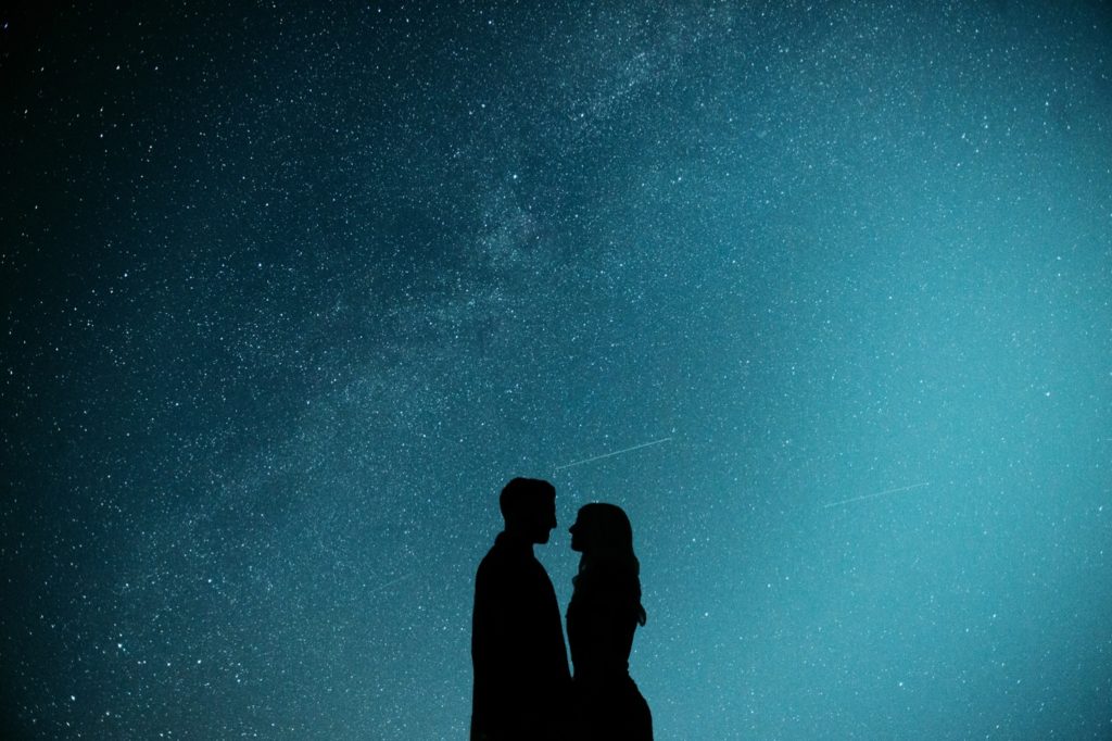 Silhouette of a couple looking at each other with the starry sky in the background during their day full of awesome elopement ideas in Colorado. 