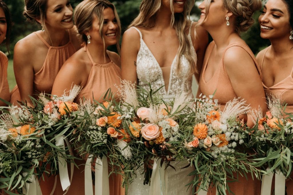 Summer bridesmaids photos in peachy colored dresses at Mustard Seed Gardens.