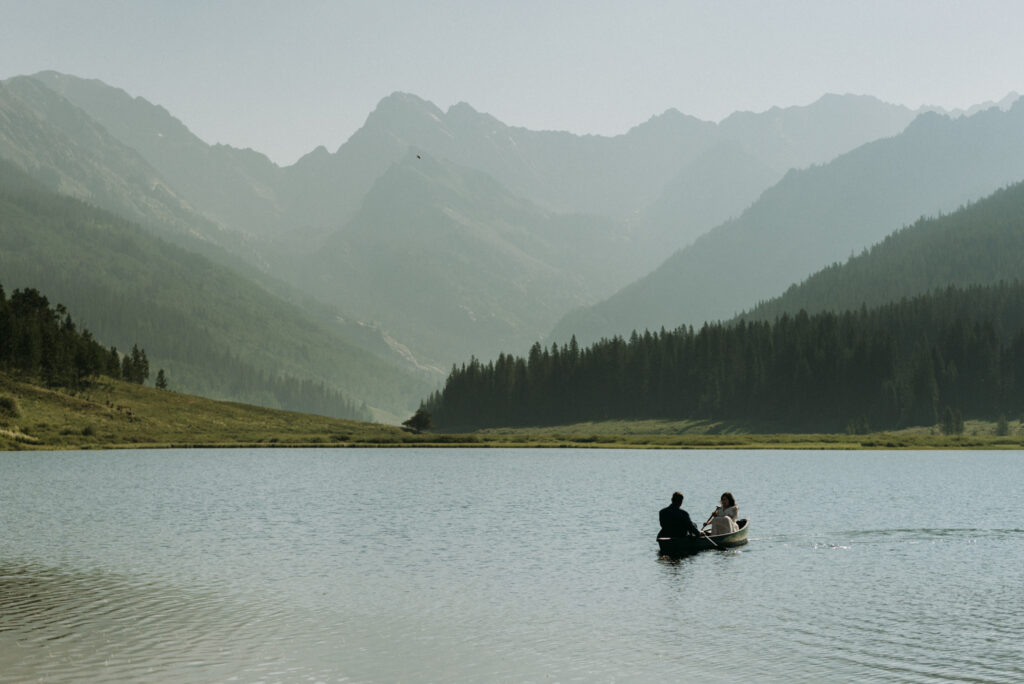 A couple canoeing on an alpine lake in Vail Colorado during their elopement day at the best micro wedding venue - Piney River Ranch