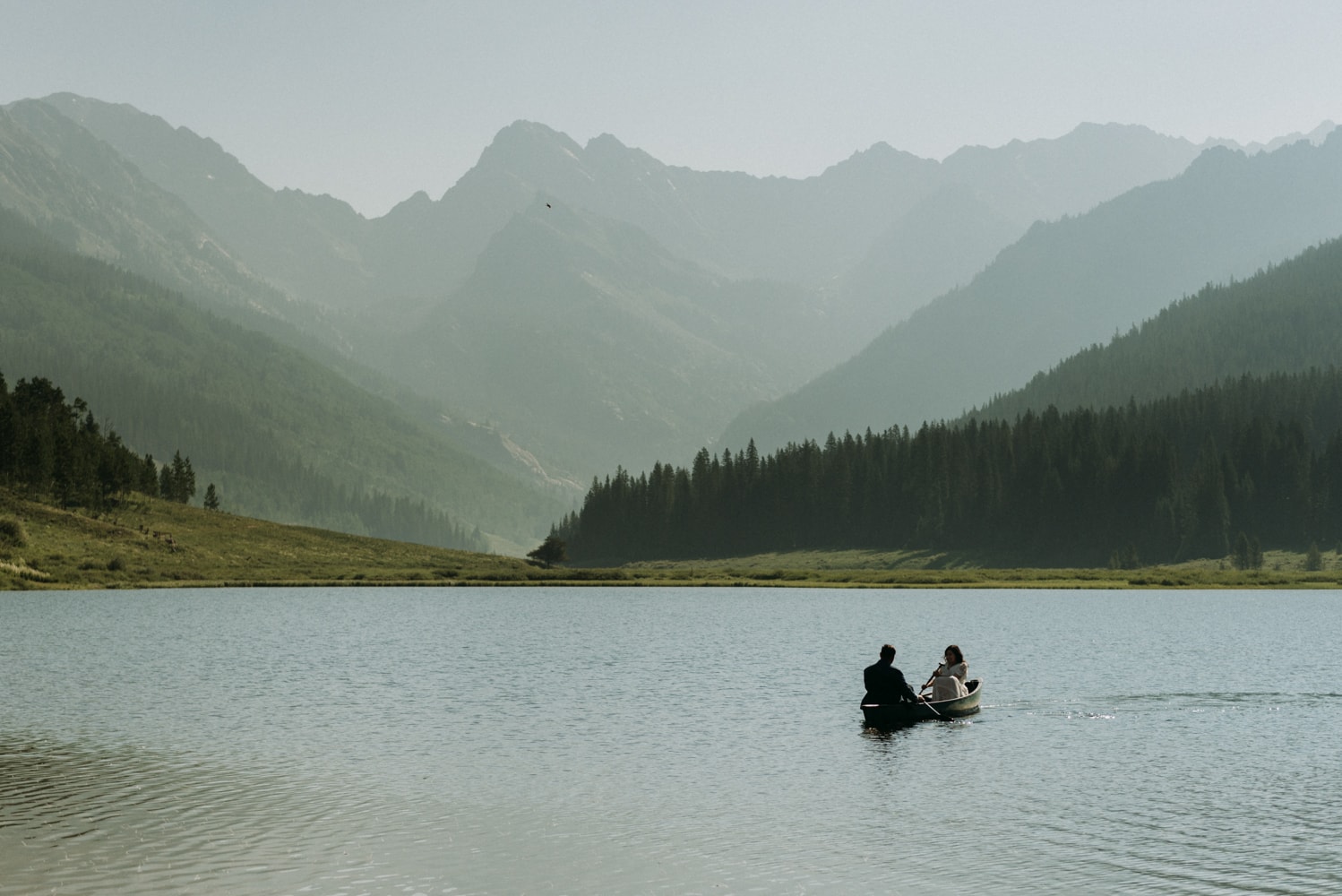 A couple canoeing on an alpine lake in Vail Colorado during their elopement day