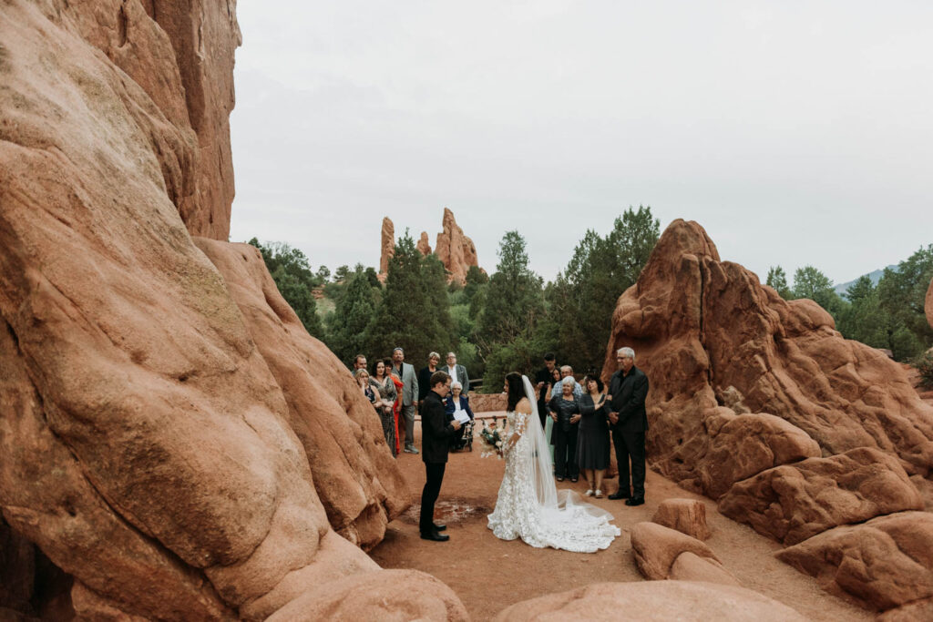 a couple is surrounded by family during their elopement ceremony at garden of the gods in colorado springs