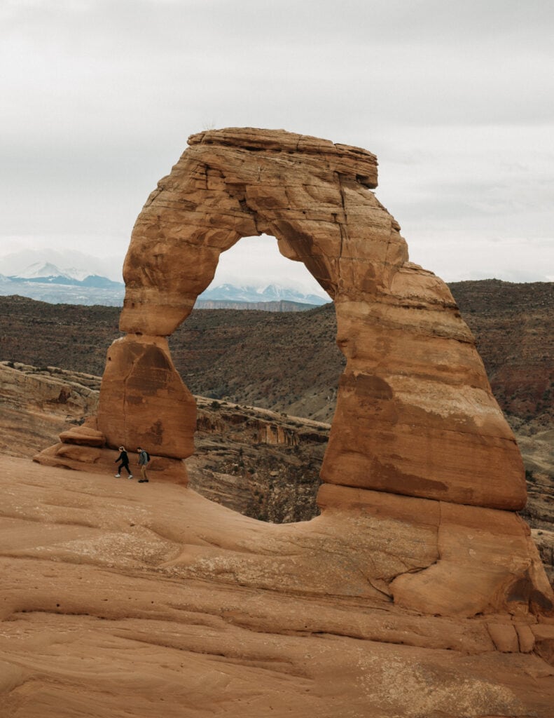 couple hiking at Sand Dune Arch at their Moab elopement