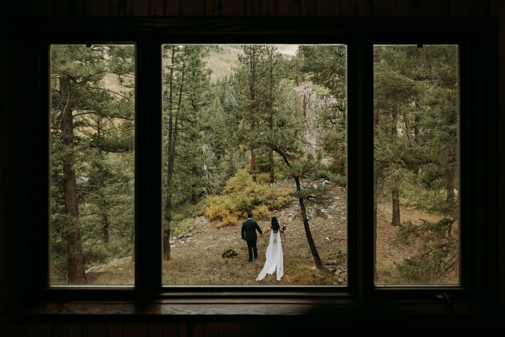 A couple walking in the forest during their San Juan Mountains Airbnb wedding