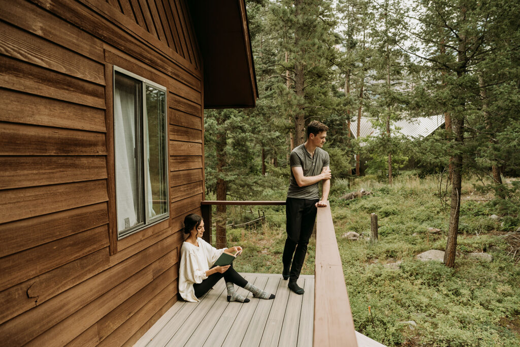 A couple reading on the porch of their forest cabin during their airbnb elopement wedding