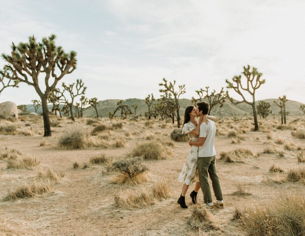 A couple kissing in the desert for their anniversary session in Joshua Tree california. Joshua tree national park engagement photos at cap rock