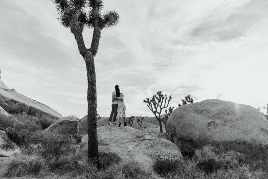 A couple running around in the desert for their anniversary session in Joshua Tree california. Joshua tree national park engagement photos at cap rock