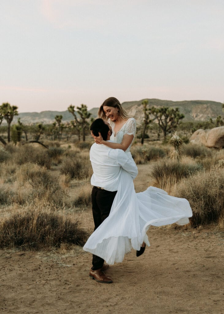 groom picking up and spinning bride during their joshua tree national park elopement