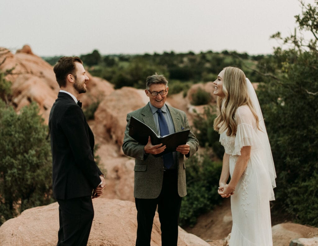 bride, groom, and officiant smiling at a national park wedding ceremony site
