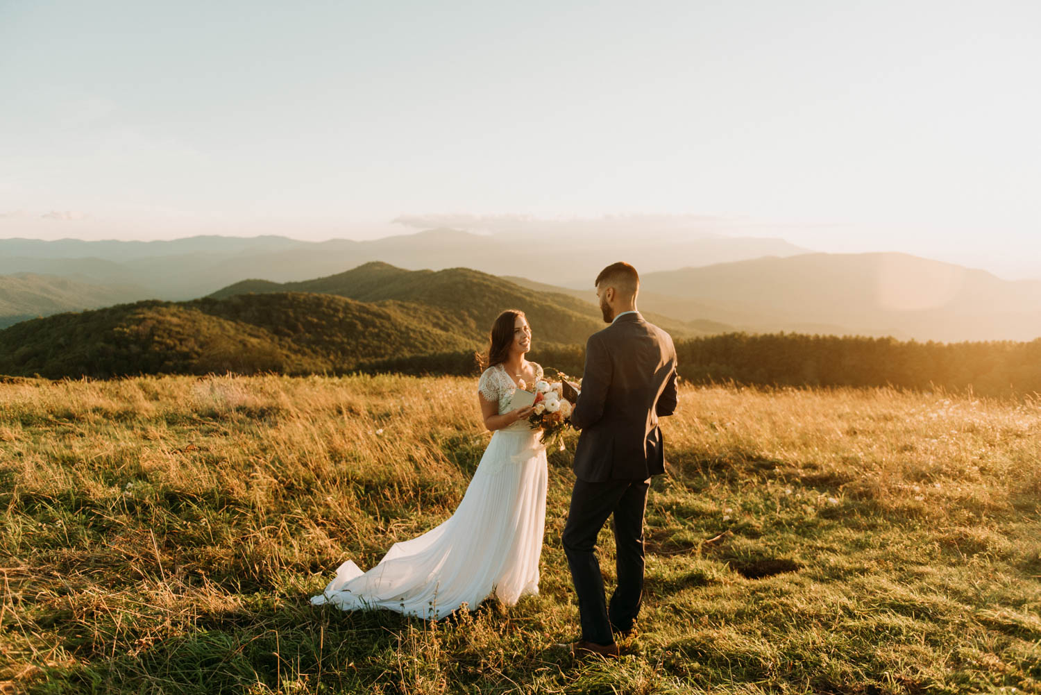 a couple says their vows overlooking a beautiful sun setting over the mountain peaks in the distance in Asheville, one of the best places to elope in North Carolina