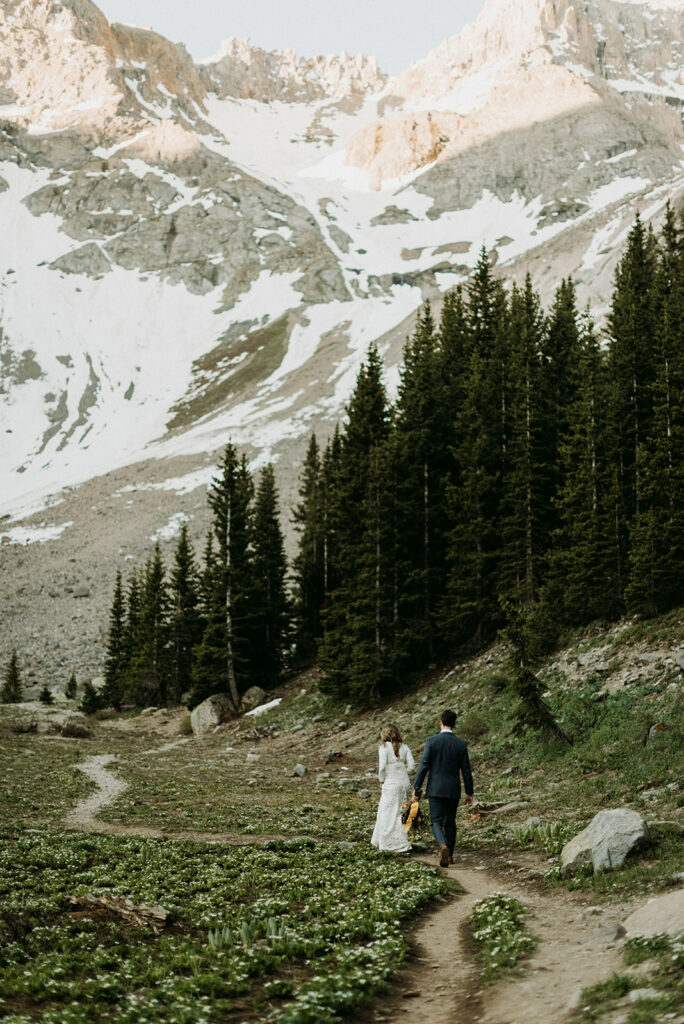 couple hiking around an alpine lake on their Alaskan elopement adventure