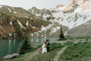 couple snuggling around an alpine lake on their Alaskan elopement adventure