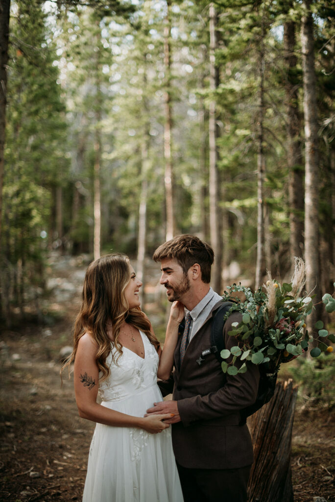 couple hiking through the forest on their Alaskan elopement adventure