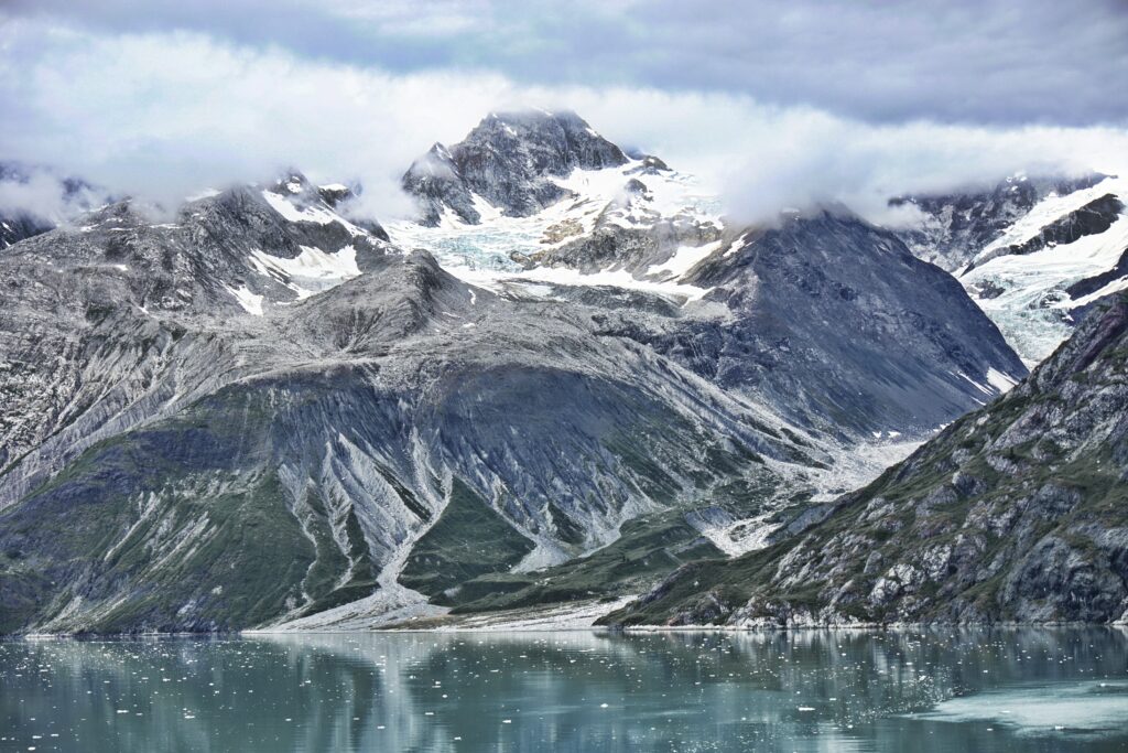 Alpine lake in front of cloud covered mountain peaks in glacier bay national park elopement
