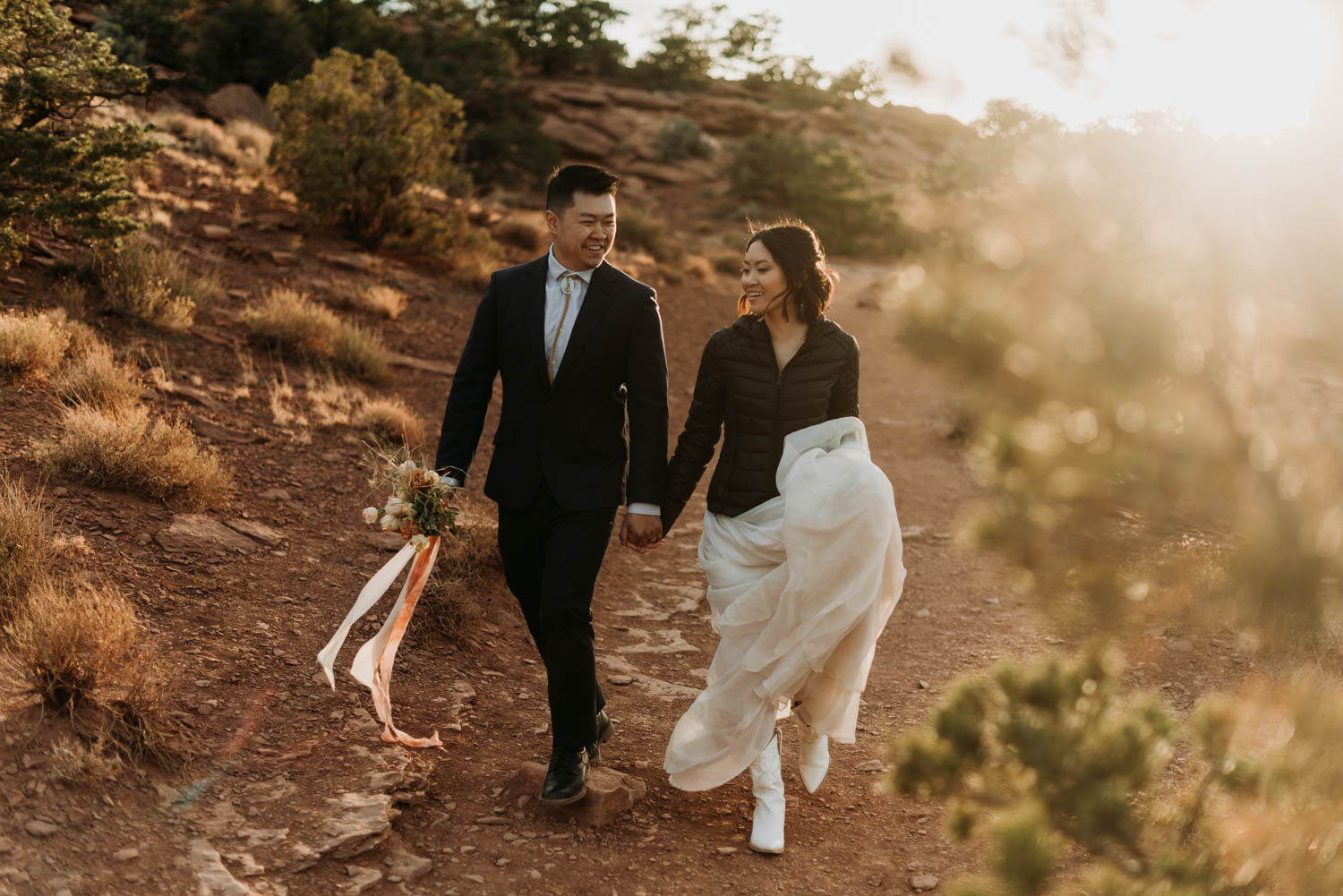 A couple walking through Capitol Reef National Park on their elopement day. Capitol Reef is one of the best places to elope in Utah