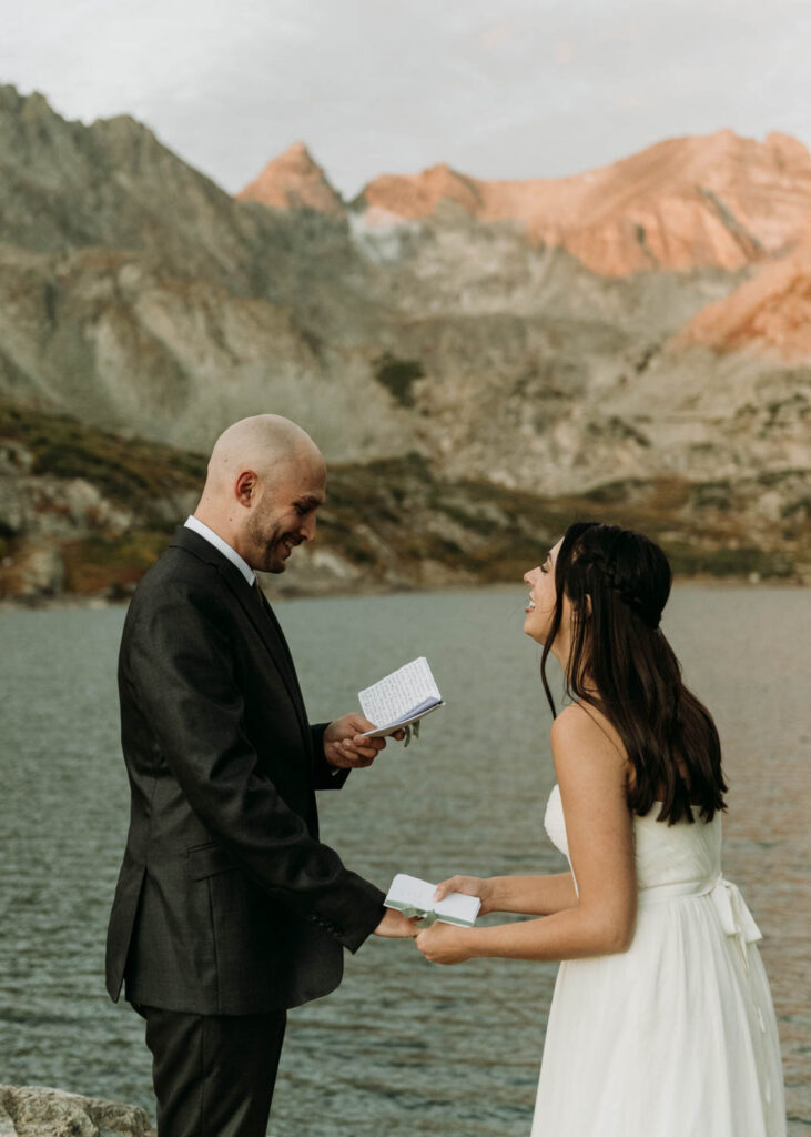 A couple laughs while sharing their vows during their lake isabelle elopement