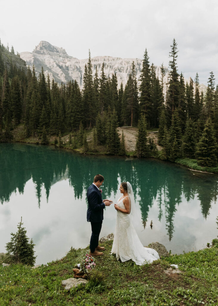 A couple saying their vows in front of an ice blue alpine lake in the San Juan Mountains of Colorado, one of the best places to elope!