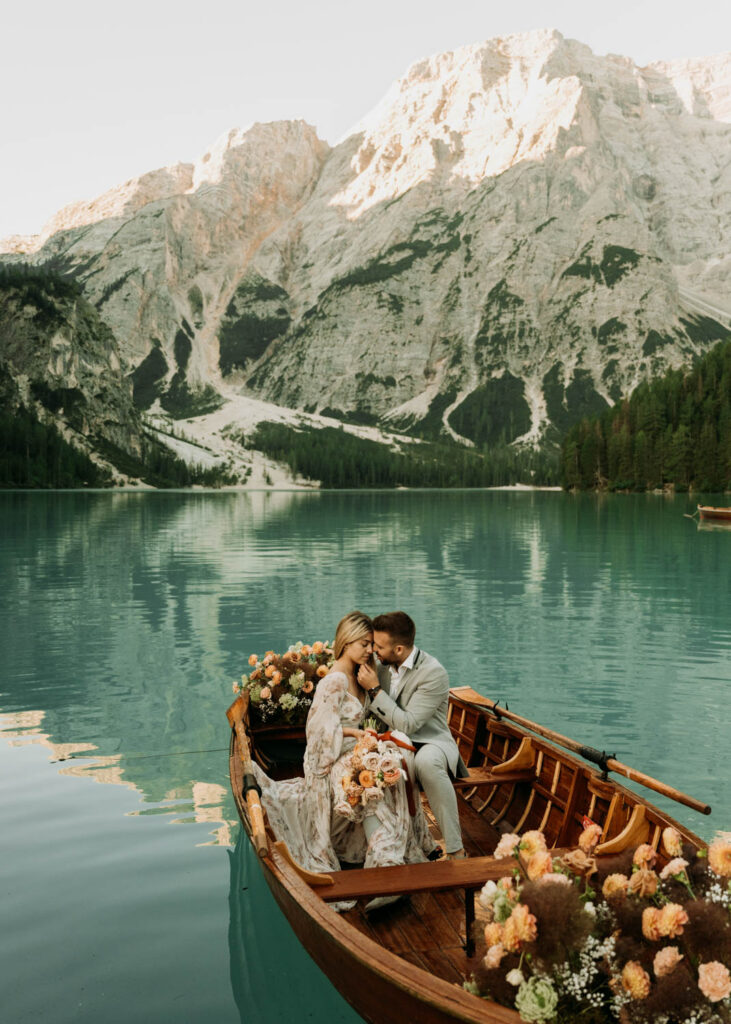 a couple sits in a canoe on lago di braies for their dolomites elopement