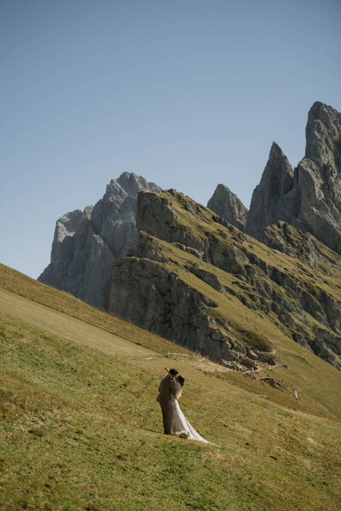 A couple embraces during their elopement in the dolomites at Seceda