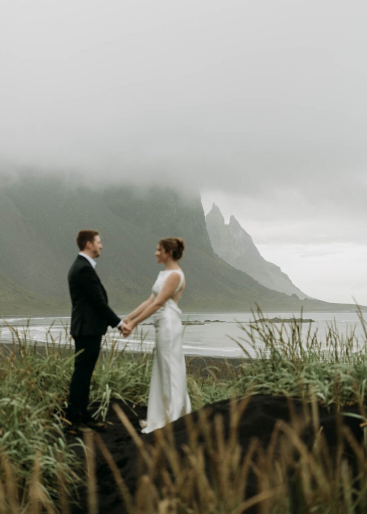 Holding hands surrounded by Iceland's magical Vestrahorn mountain during a Stokksnes elopement